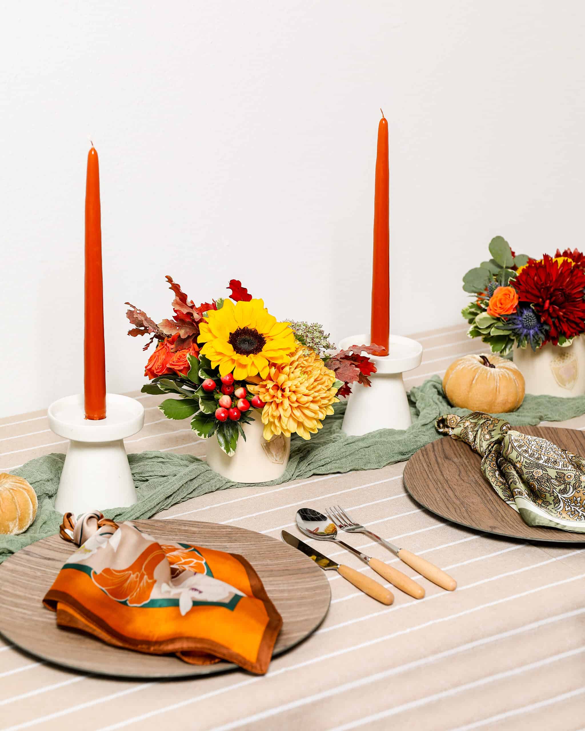 Cross-country trio - 3 flower arrangements in an acorn container on a dinner table for Thanksgiving