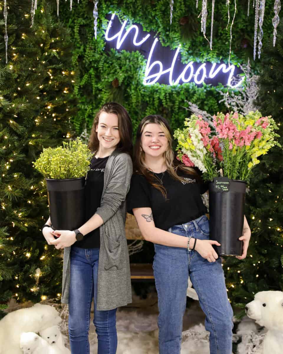two in bloom florist workers holding buckets of flower stems for happy hour 