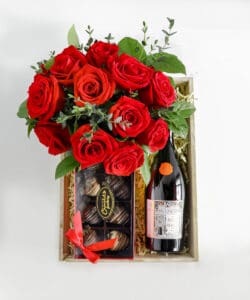 gift basket with red roses, wine, and chocolate covered strawberries